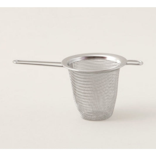 Filtre à thé inox posé sur une tasse
