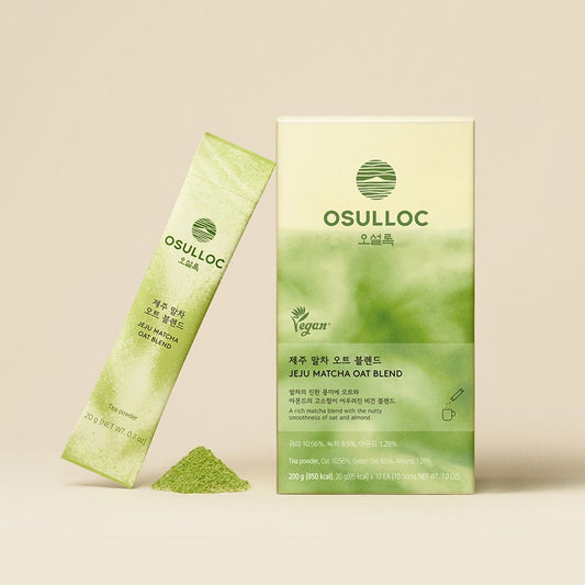 Boîte verte OSULLOC Jeju Matcha Oat Blend et un stick de matcha à l'avoine posé avec de la poudre de matcha