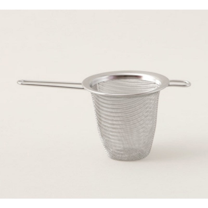 Filtre à thé inox posé sur une tasse