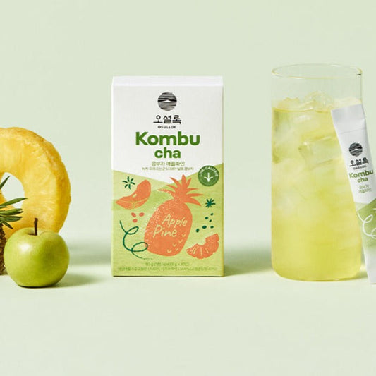 Boîtes de Kombucha OSULLOC Calamango et Apple Pink avec des verres de boisson pétillante fraîche et des fruits coupés.
