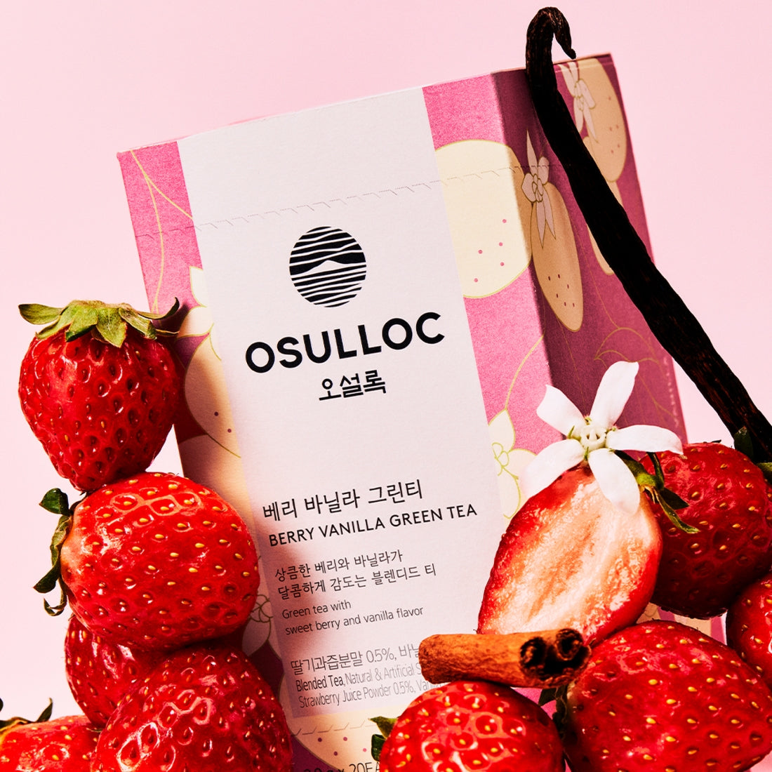 Sachet rose OSULLOC Berry Vanilla Green Tea entouré de fraises fraîches, bâtons de vanille et fleurs de cannelle.