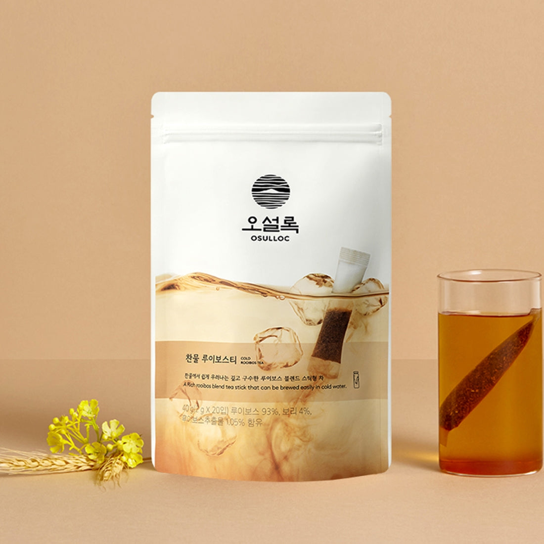 Sachet de ColdOSULLOC Cold Rooibos Tea  montrant un stick en train d'infuser dans un verre d'eau glacée.
