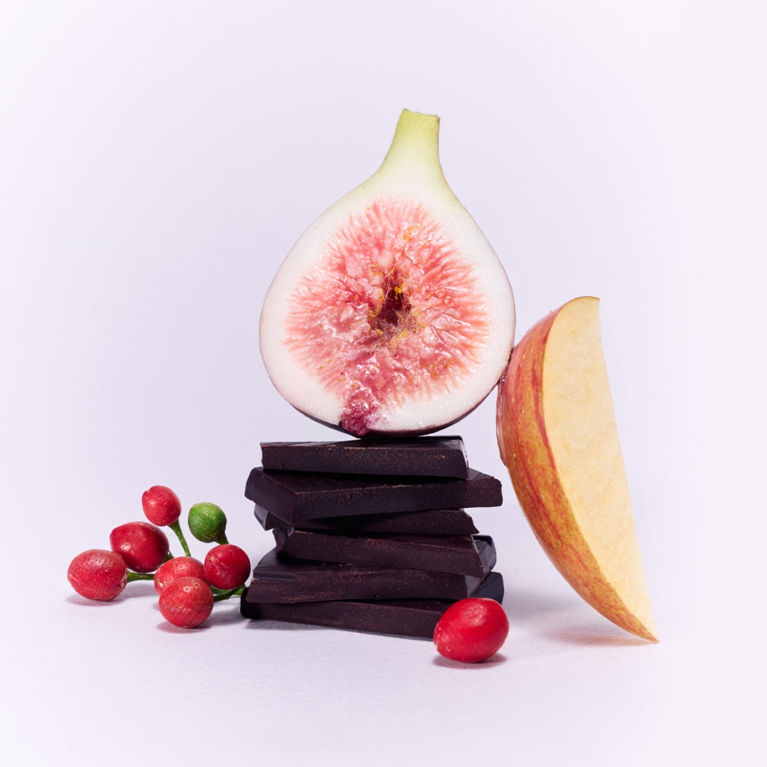 une figue ouverte, de tranches de pomme et de carrés de chocolat noir.
