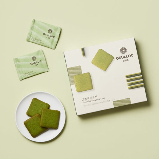 Biscuits Langues de Chat OSULLOC vert clair avec leurs emballages individuels sur fond vert pastel.