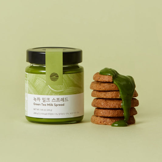 Pot de OSULLOC Green Tea Milk Spread Pâte à Tartiner au Thé Vert à côté de biscuits nappés de crème verte 