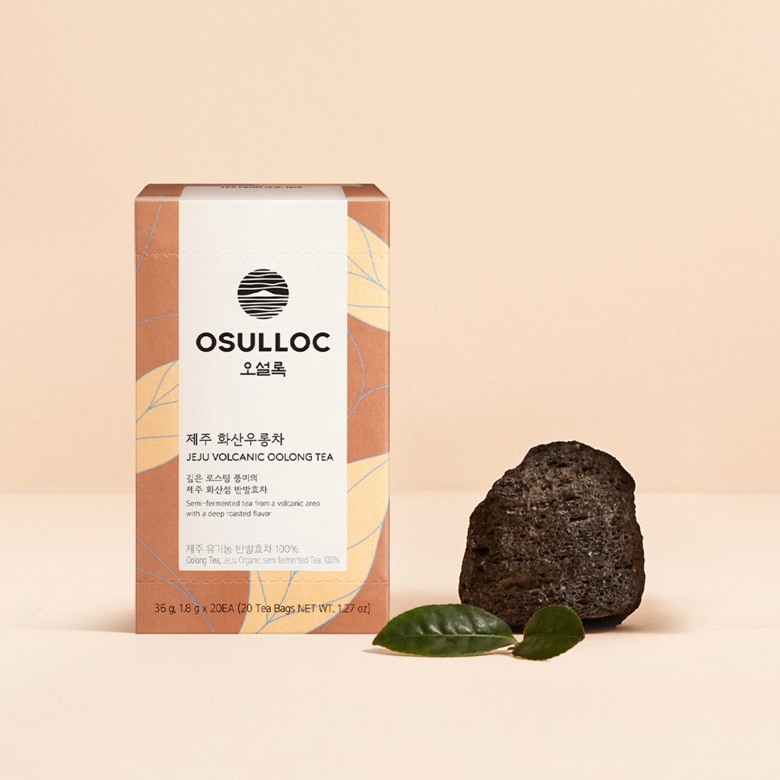 Boîte de thé Oolong Jeju Volcanic OSULLOC avec une tasse de thé ambrée et des feuilles de thé infusées.