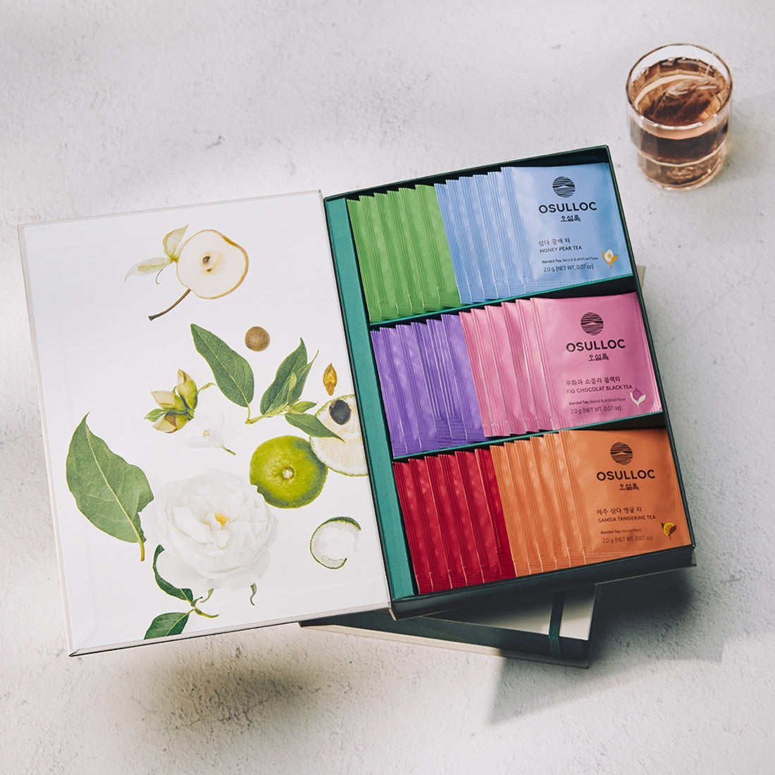 Coffret beige ouvert OSULLOC Tea Variation O présentant 6 rangées de sachets de thés colorés.