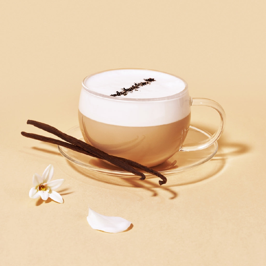 tasse de OSULLOC Vanilla Honey Black Tea posée à côté de gousses de vanille, de fleurs blanches 